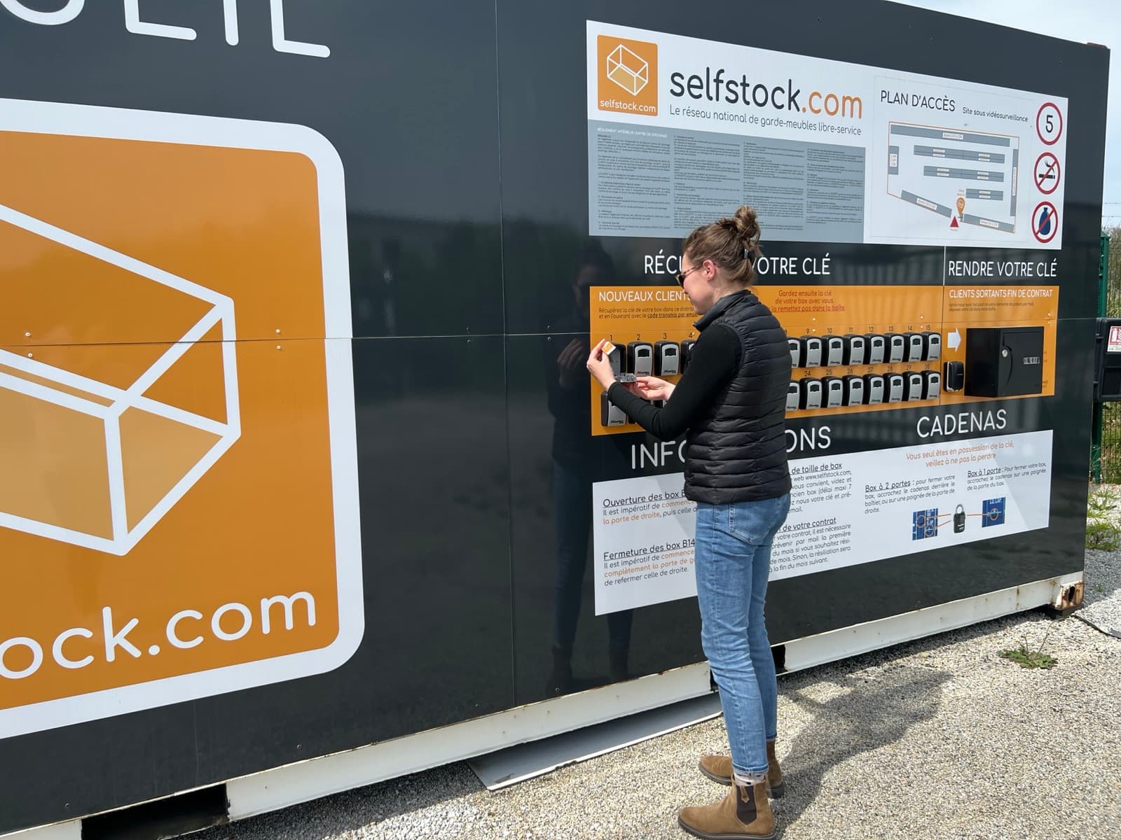 Une cliente récupère la clé de son box dans le distributeur de boîtiers à code, à l'entrée d'un centre selfstock.com